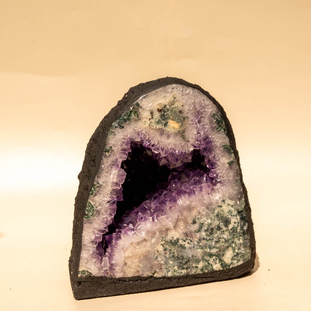 Amethyst geode with a dark purple interior on a beige background