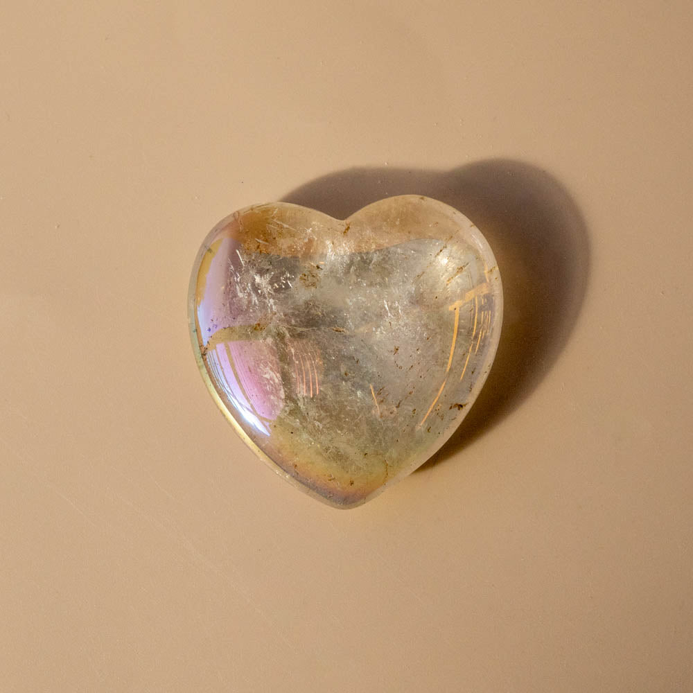 Heart-shaped Angel Aura crystal on a beige background