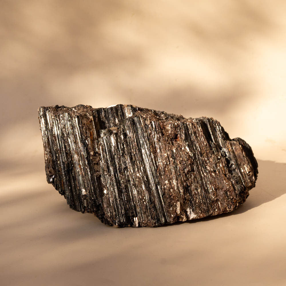 Large Black Tourmaline Schorl with Mica inclusions on beige background