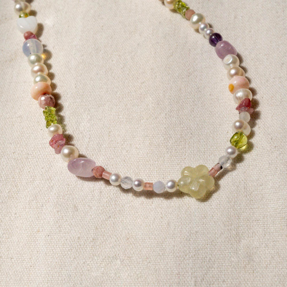 Necklace with multicolored beads on a beige fabric background