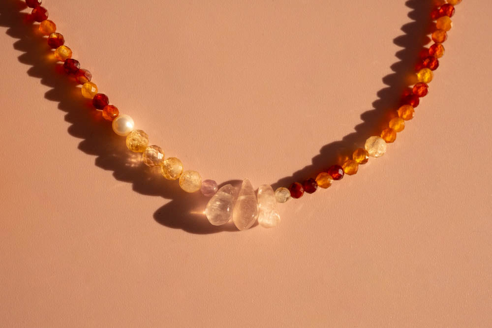 Sun chaser Necklace with multicolored beads on a pink background