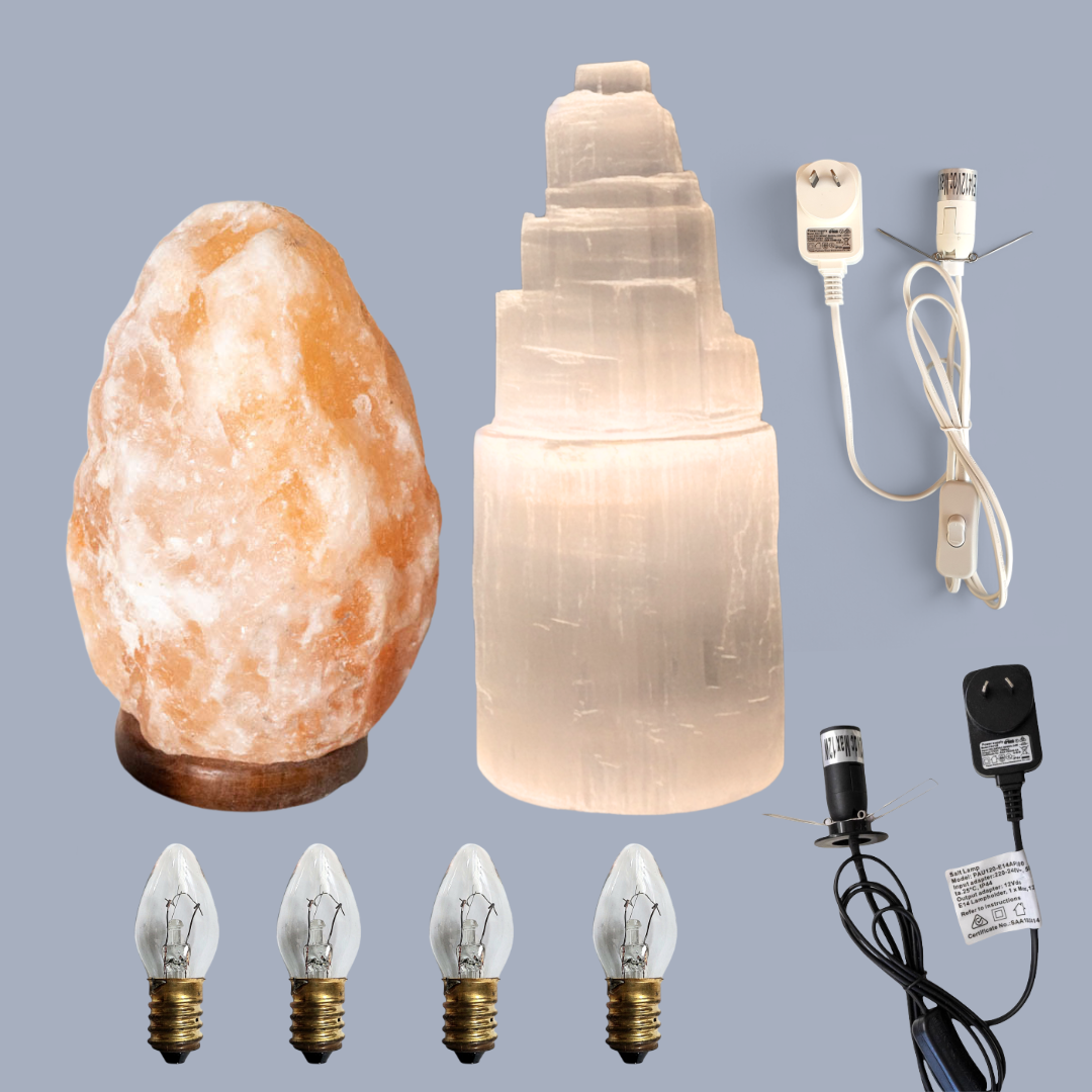 Himalayan salt and selenite lamp set with, bulb holder, and light bulbs on a gray background