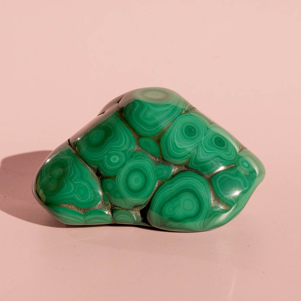 Green malachite stone on a pink background