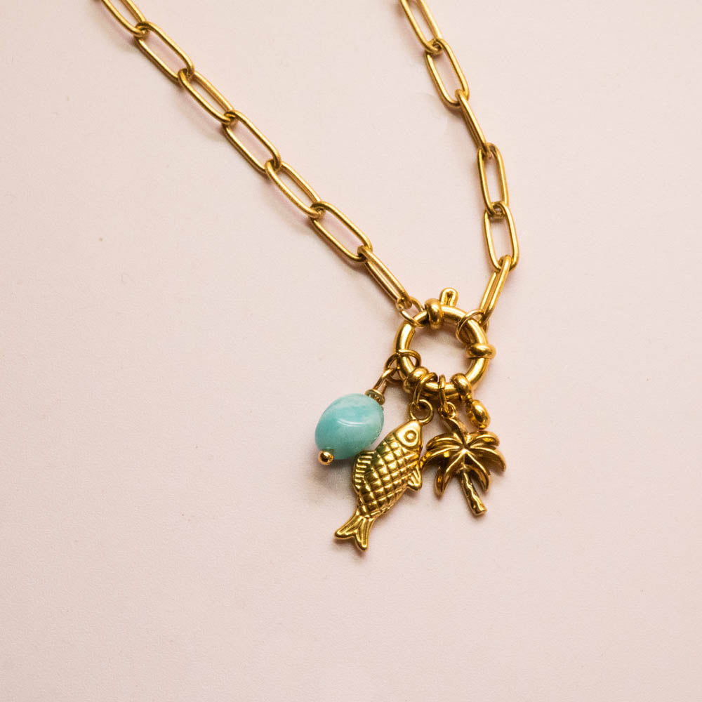Gold paperclip chain necklace with a lobster clasp and three charms: a gold fish, a gold palm tree, and a light blue bead.