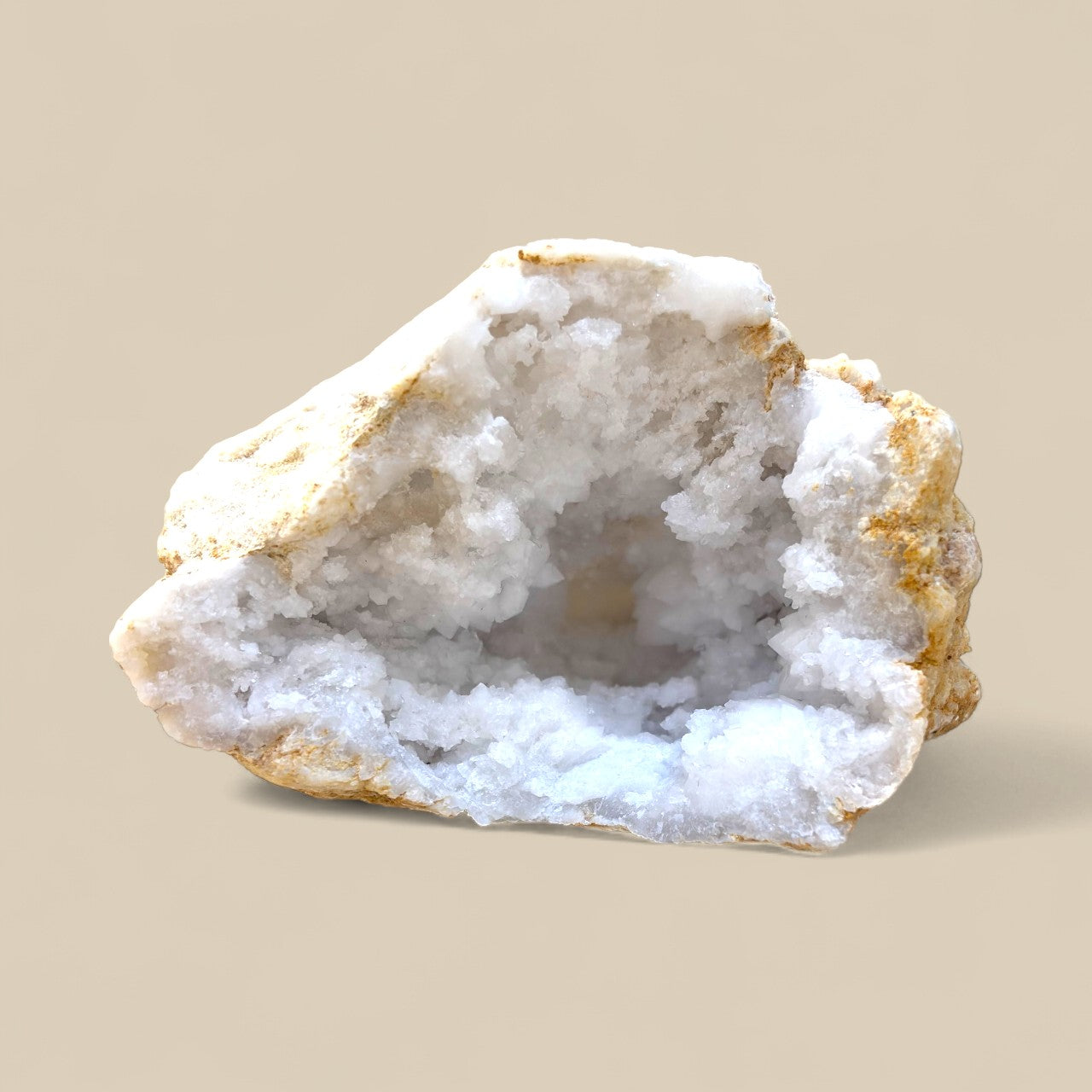 Geode with white crystal interior on a beige background