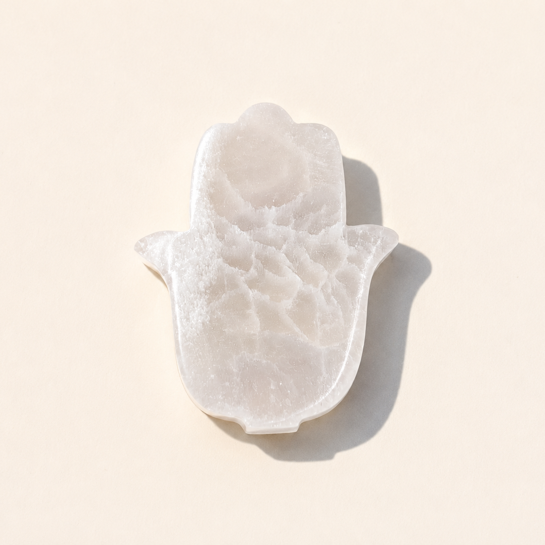 Selenite Hamsa Charging Plate on cream background