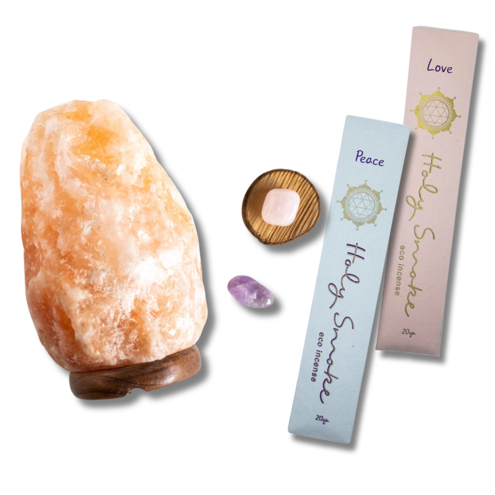 Himalayan salt lamp, incense sticks, and crystals on a white background