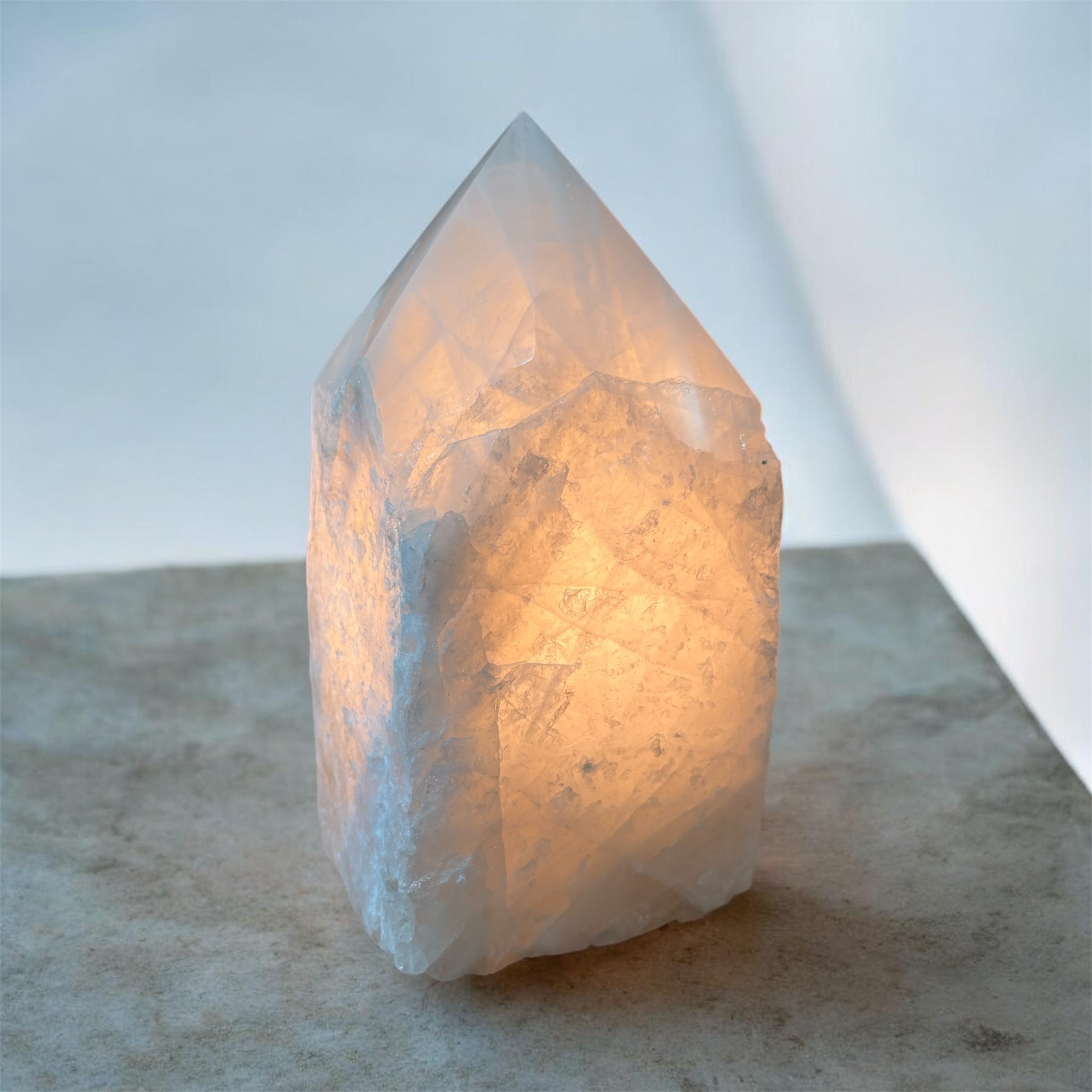 White Quartz Crystal lamp with a soft glow on a neutral background