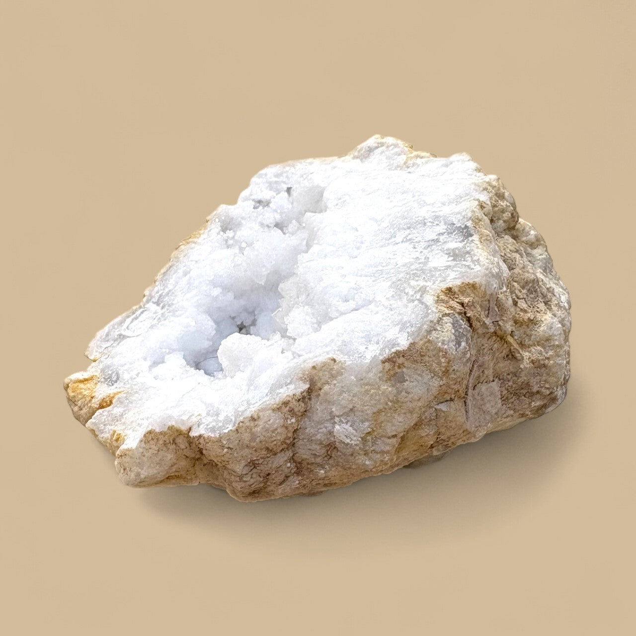 Quartz Geode with white crystalline structure on a beige background
