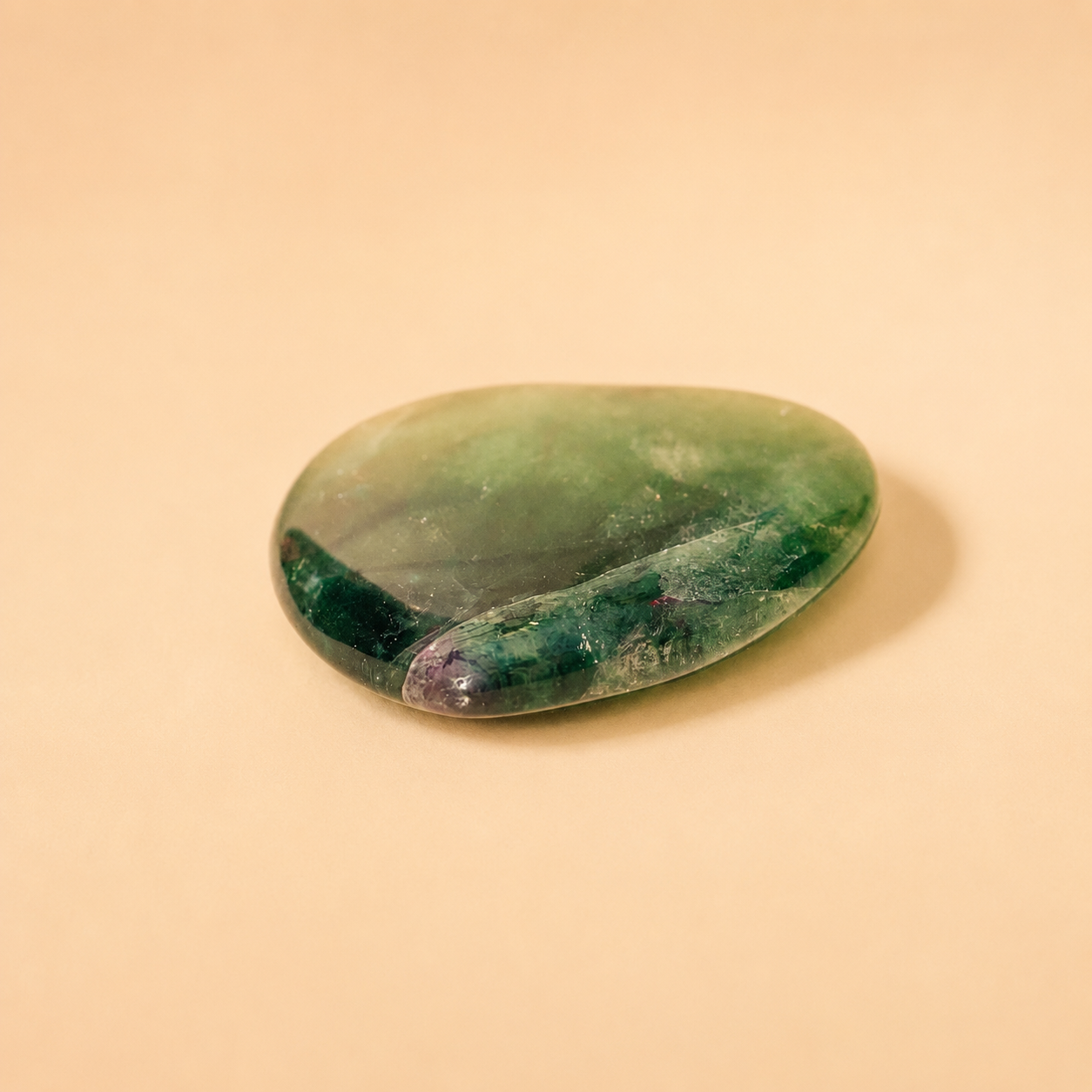 Green fluorite crystal on a beige background