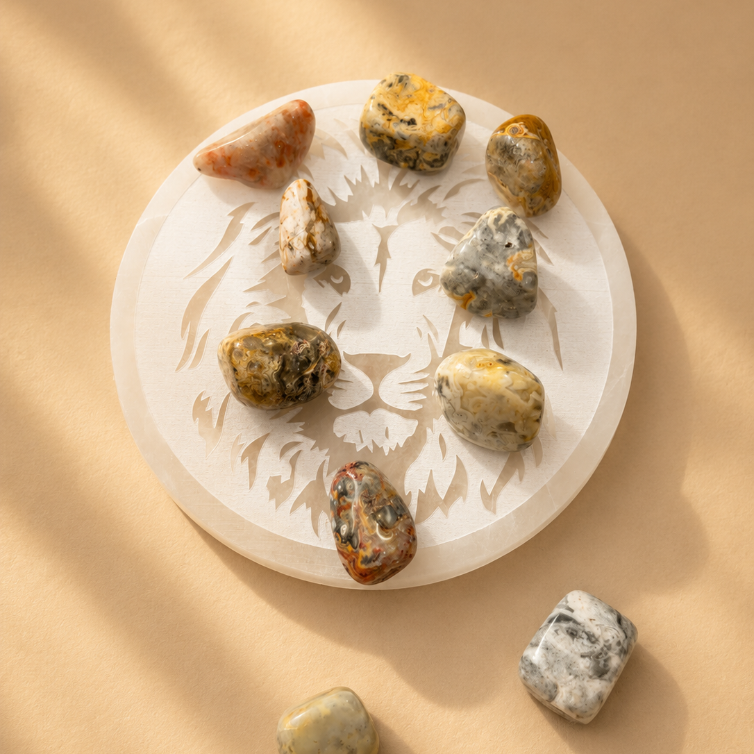 Crazy Lace Agate tumbled stones on Selenite charging plate on a beige background