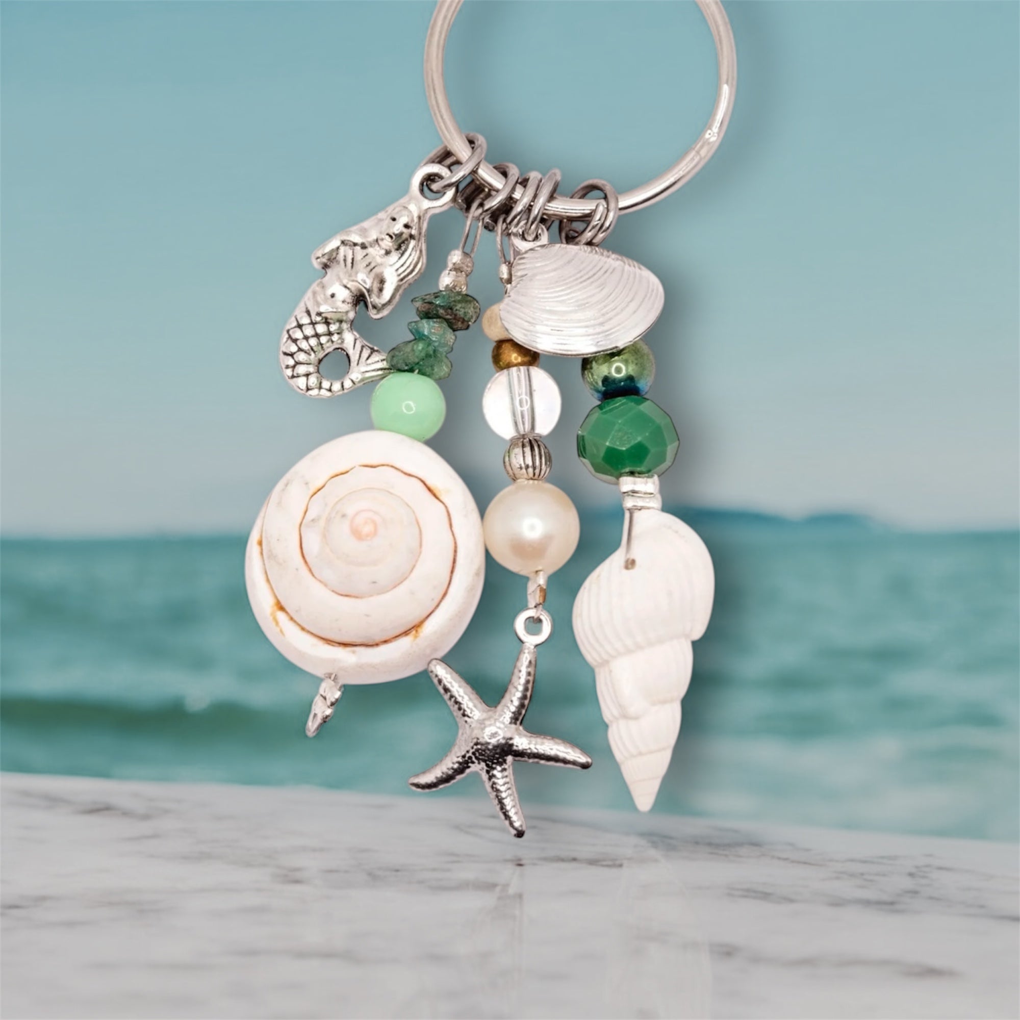 Green mermaid keyring on beach 