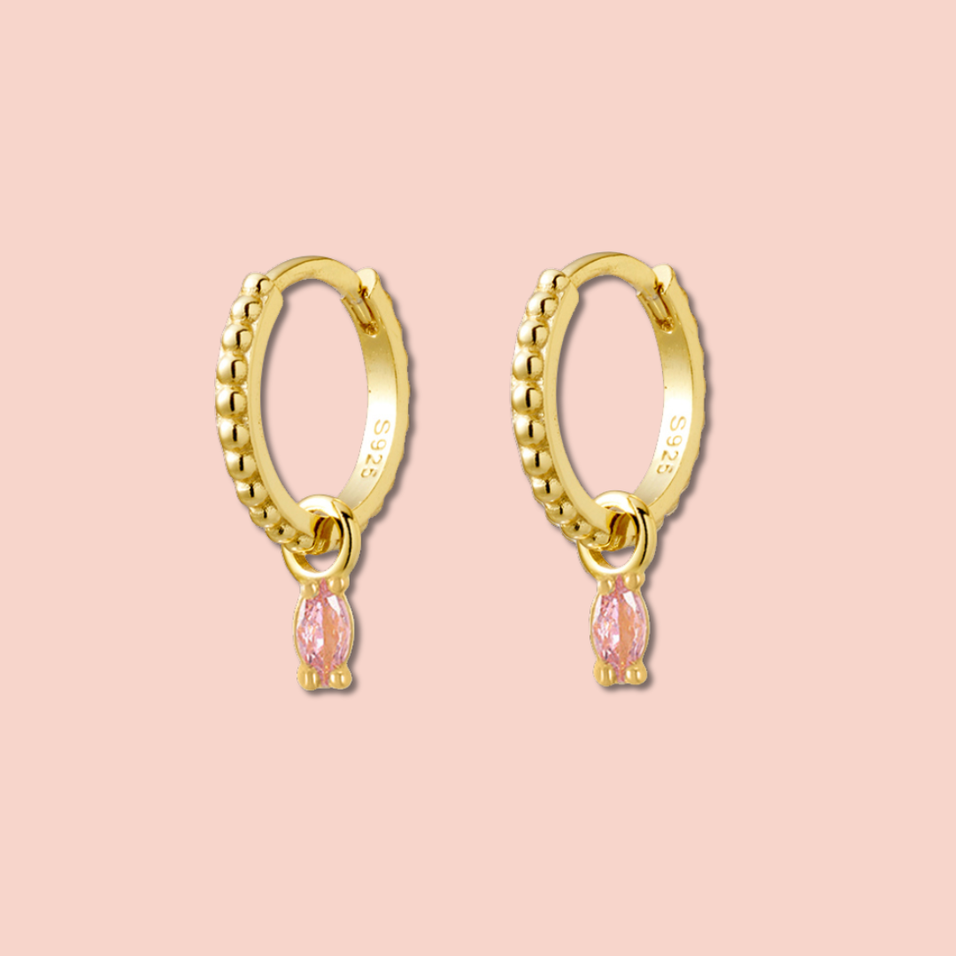 Pink charm gold hoops on pink background 