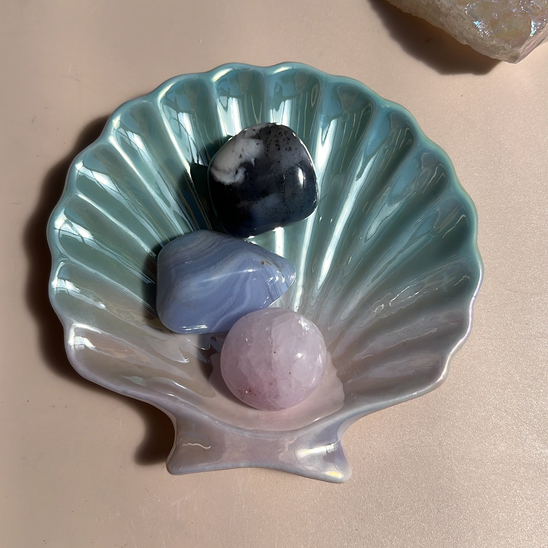 Decorative shell with colorful stones on a beige surface