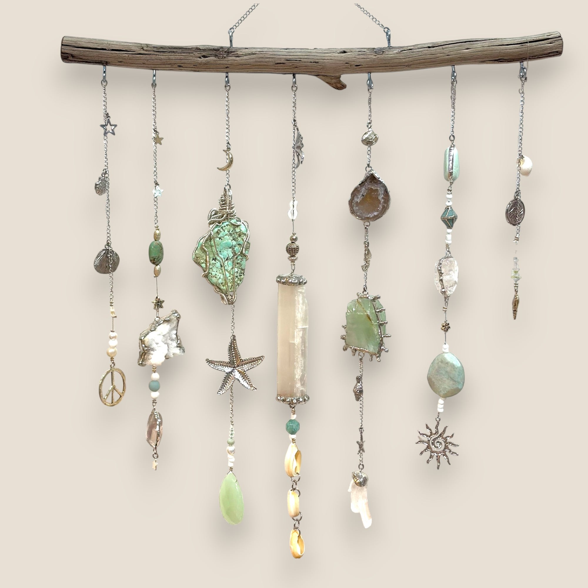 Decorative hanging mobile with beads and  natural crystals on a driftwood