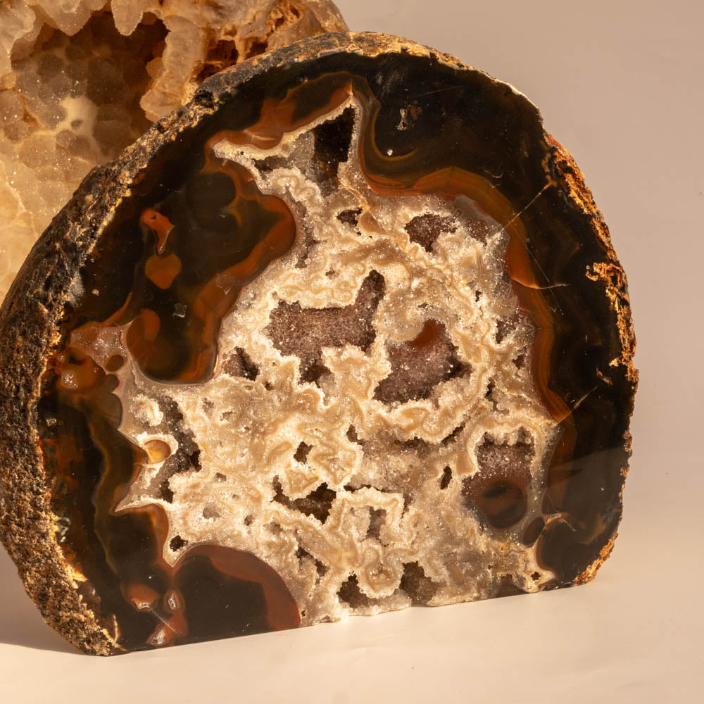 Close-up of a sliced geode with intricate patterns and colors on a beige background