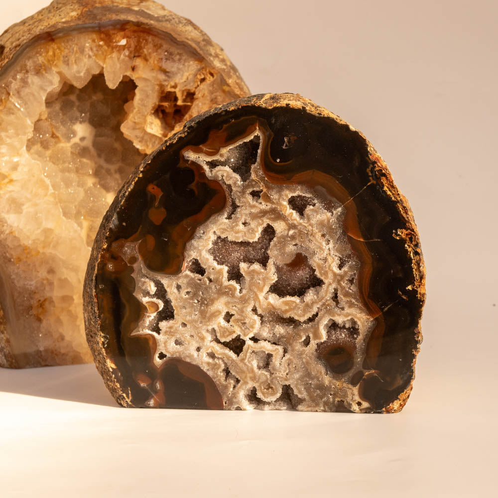 Close-up of a cut geode with intricate crystal formation on a beige background