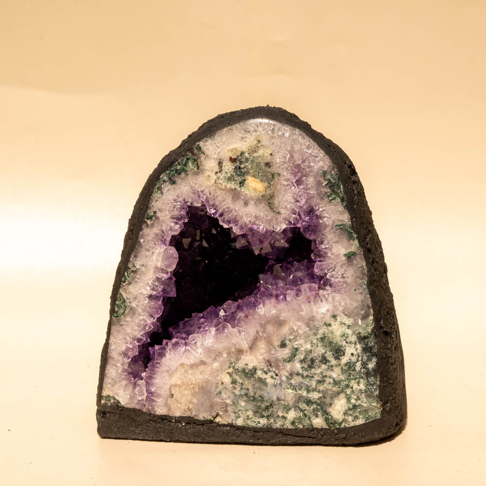 Amethyst geode with a dark center on a beige background