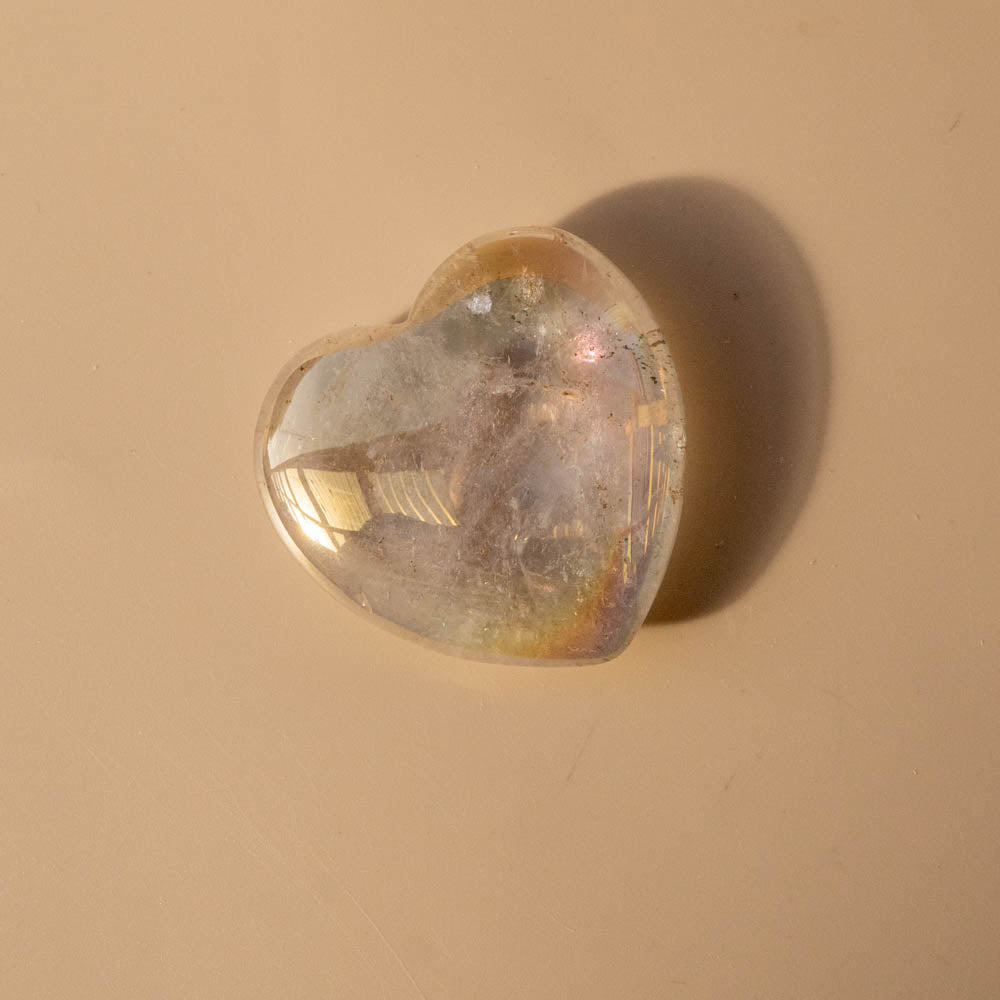 Heart-shaped Angel Aura crystal on a beige background