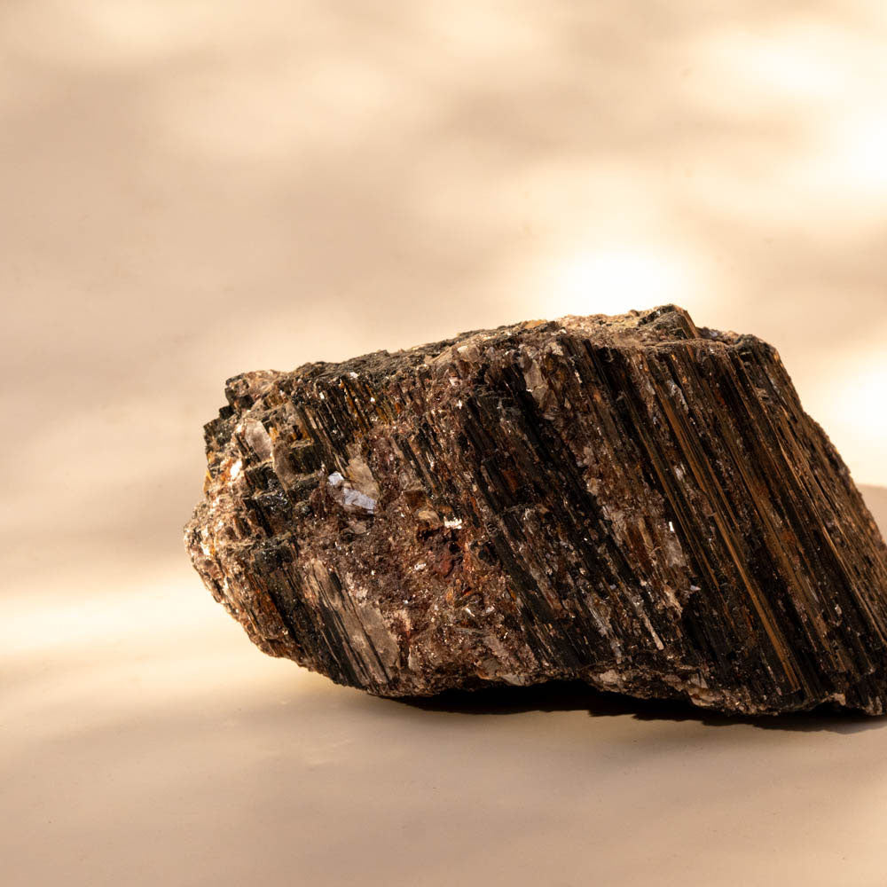 Large Black Tourmaline Schorl with Mica inclusions on beige background