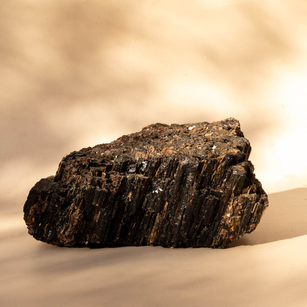 Large Black Tourmaline Schorl with Mica inclusions on beige background