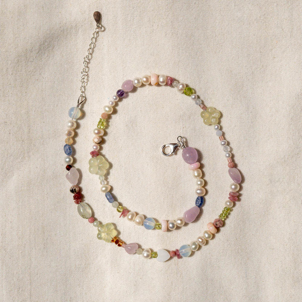 Multicolored beaded necklace on a beige fabric background