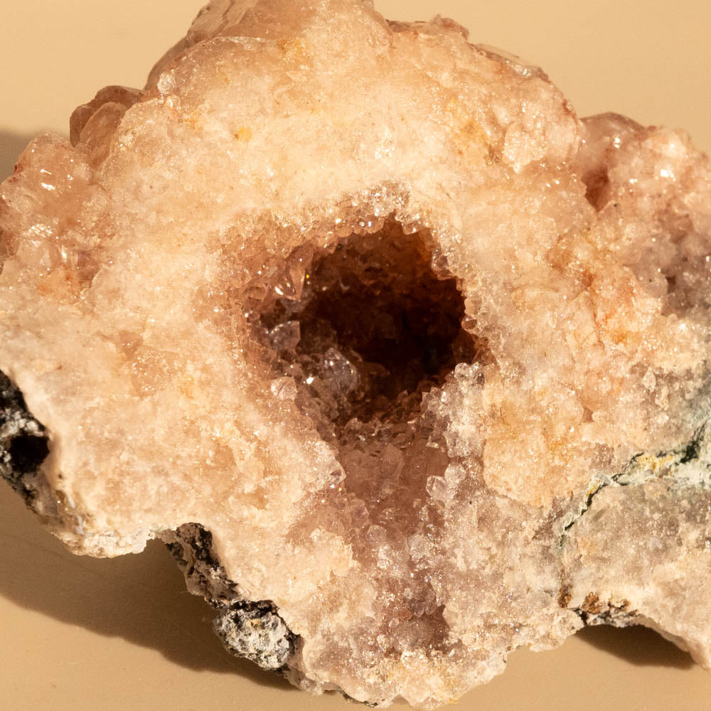 Pink Amethyst crystal rock on a beige background