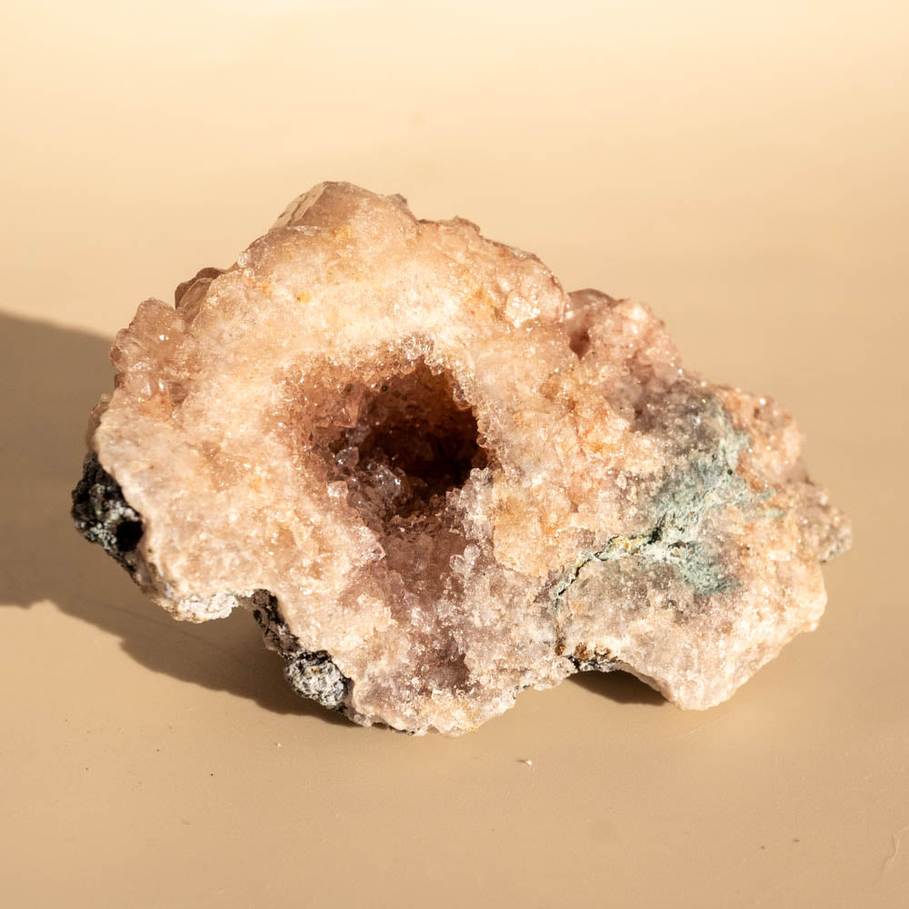 Pink Amethyst crystal rock on a beige background