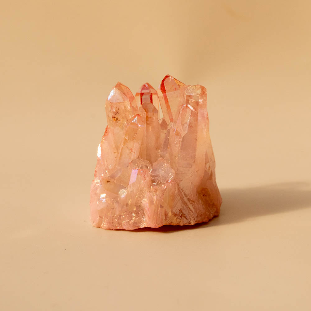 Pink aura crystal formation on a beige background