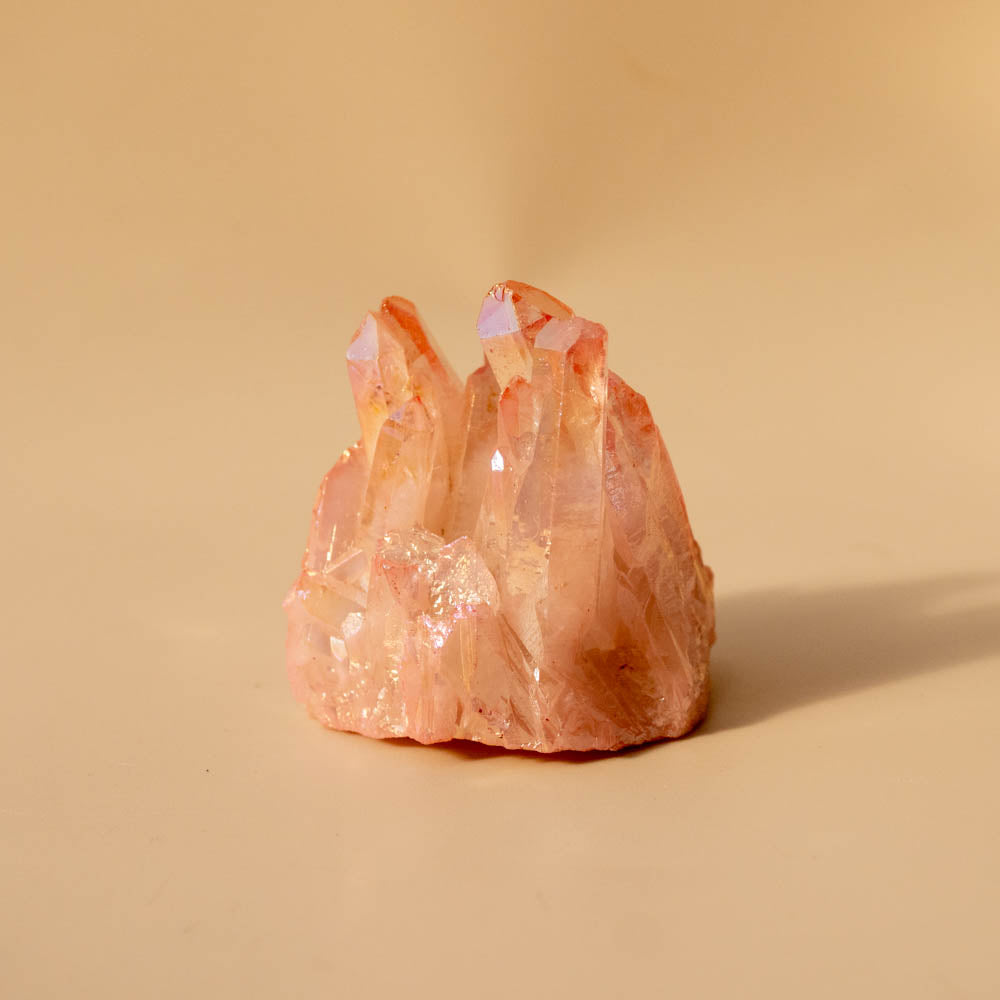 Pink aura crystal formation on a beige background