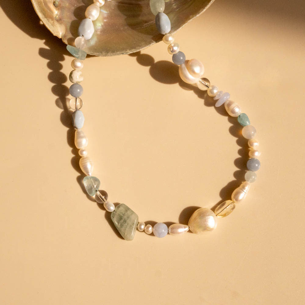 Beaded bracelet with pearls and stones on a beige background