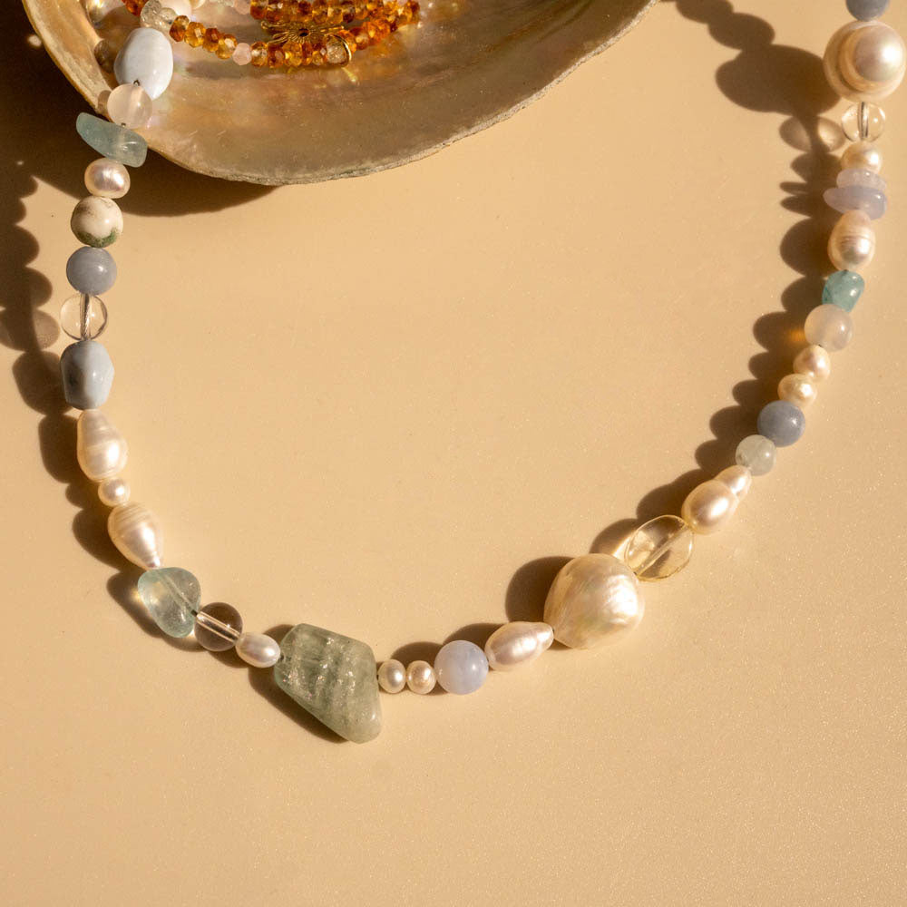 Necklace with pearls and stones on a beige background