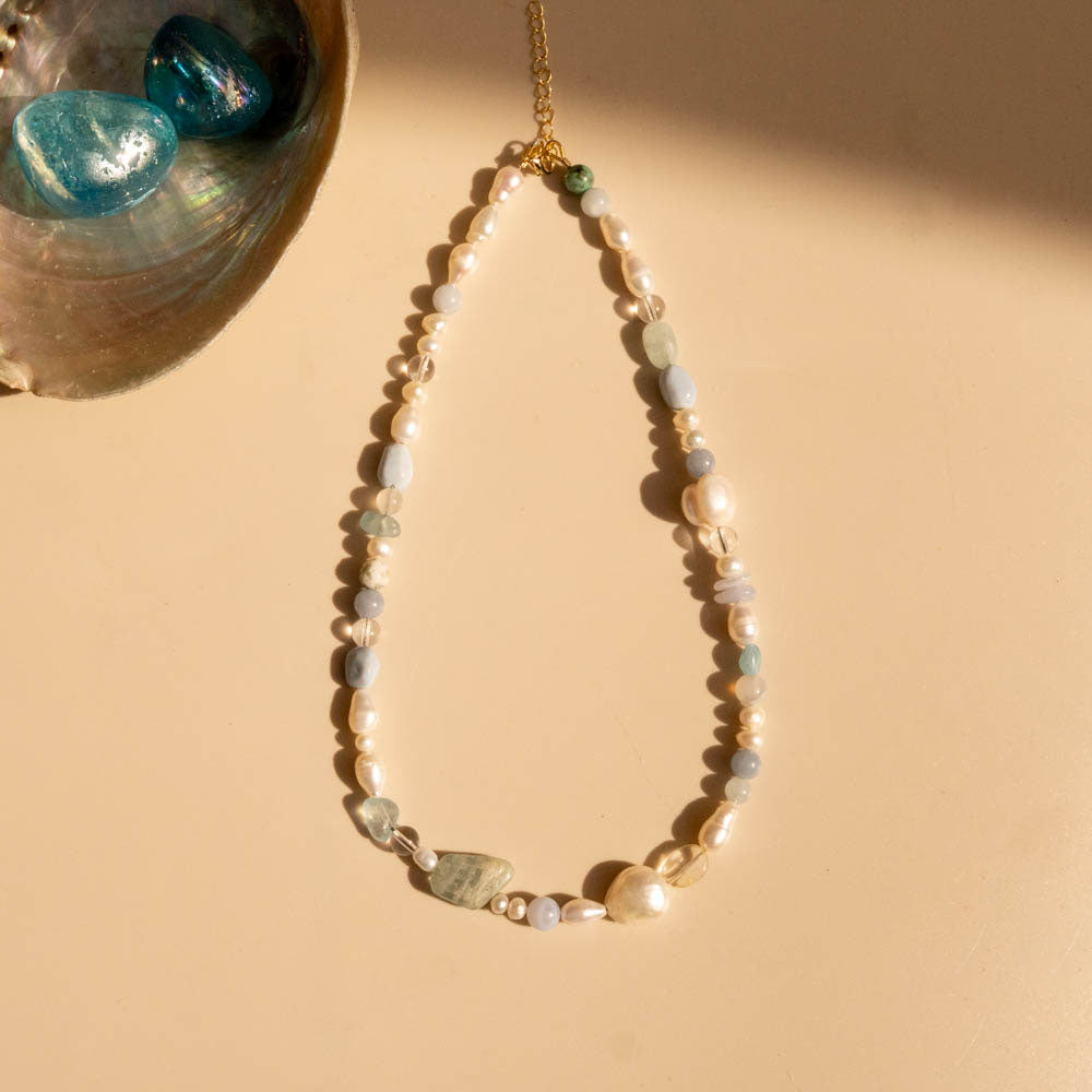 Necklace with pearls and gemstones on a beige background
