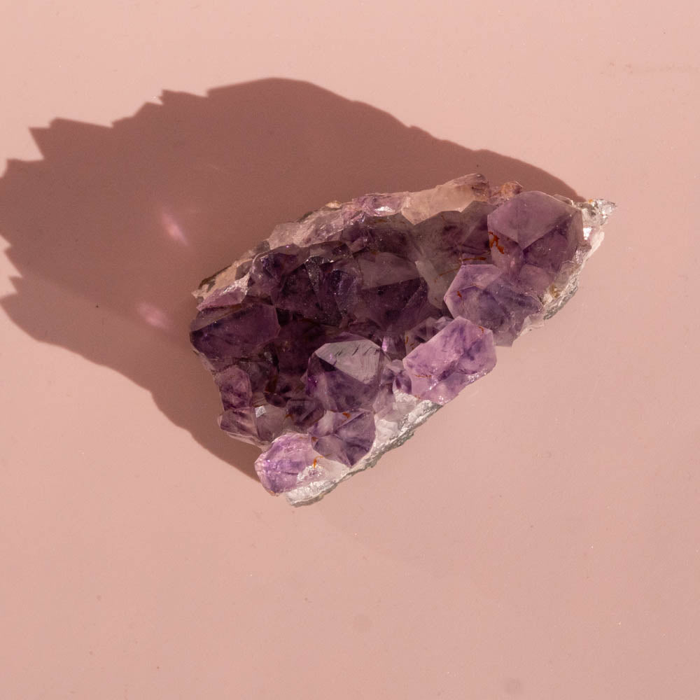 Amethyst crystal on a pink background