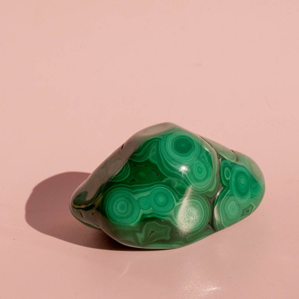 Green malachite stone on a pink background