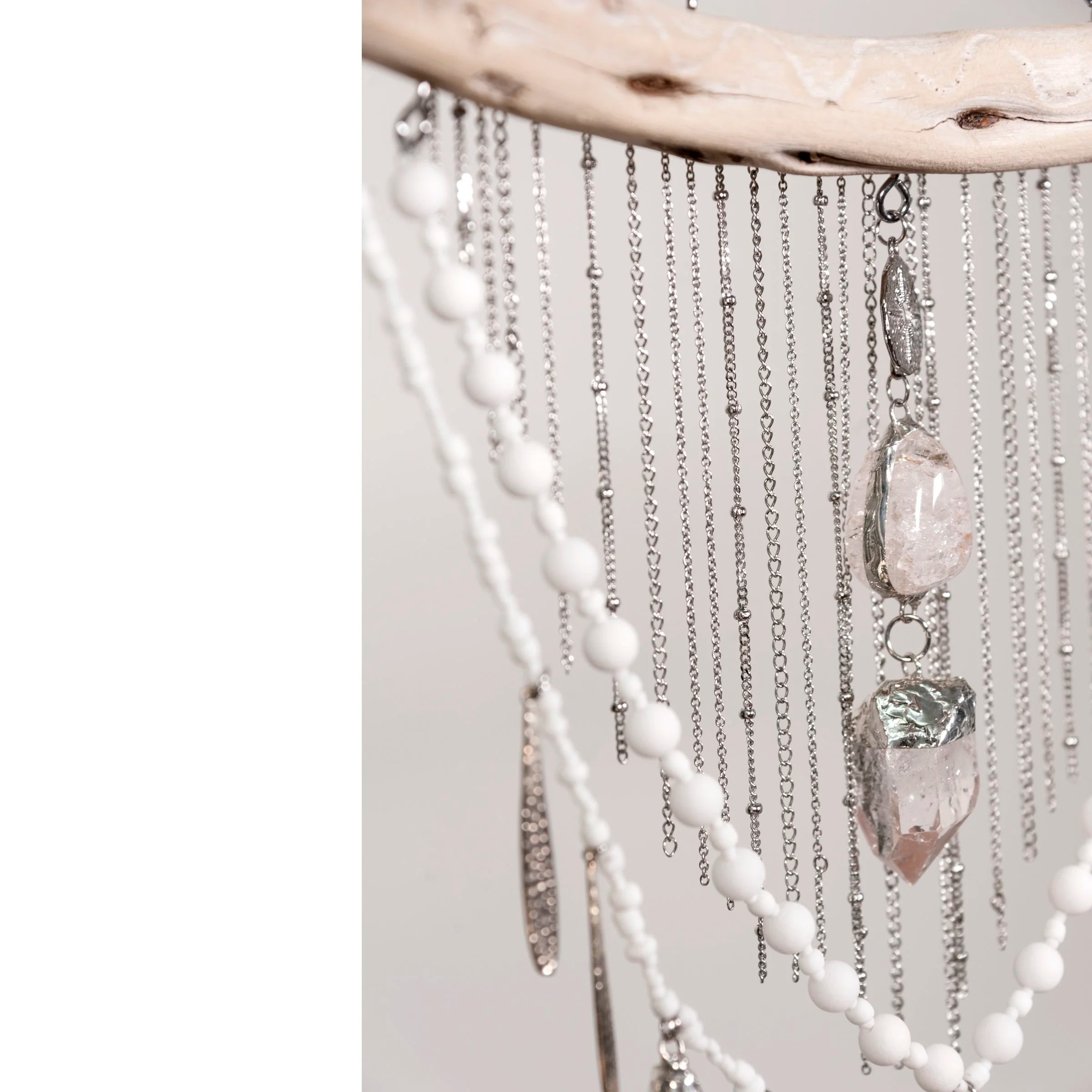 Decorative wall hanging with Howlite with Quartz crystals and beads on a white background
