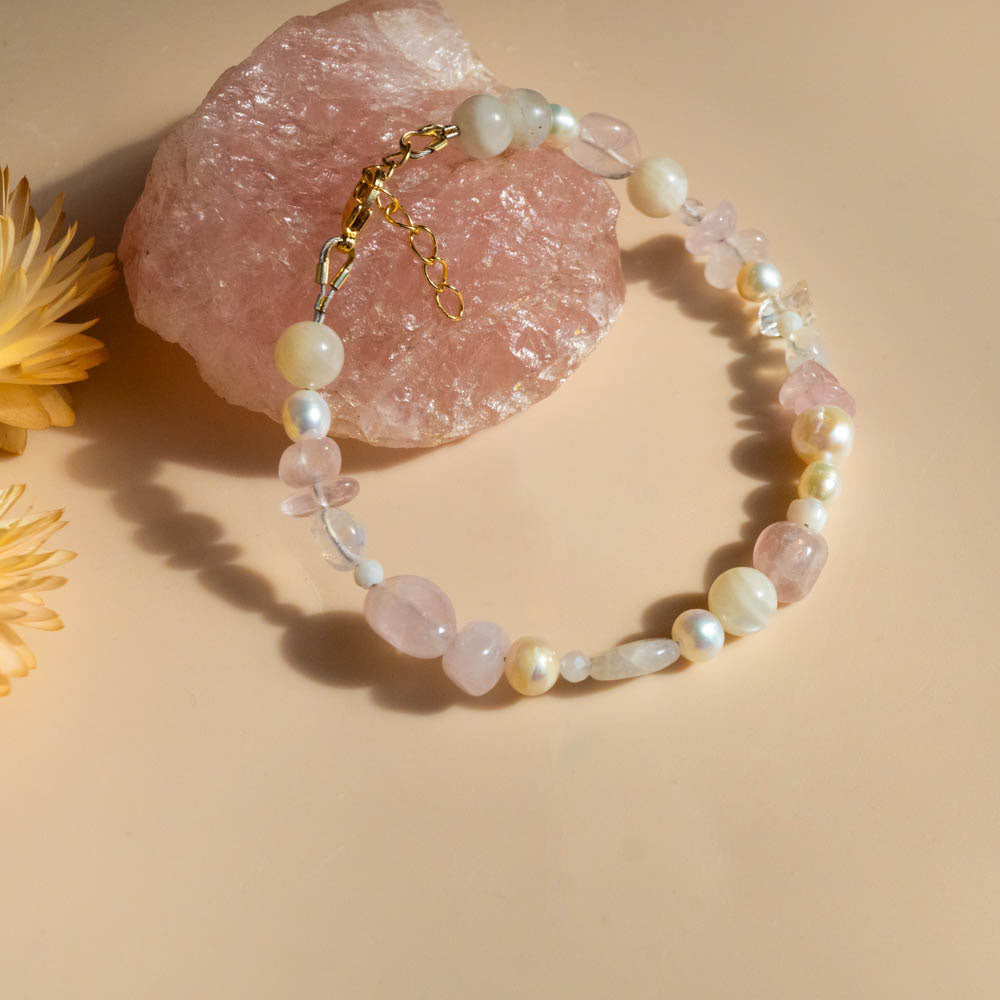 Beaded bracelet with rose quartz crystals and fresh water pearls on a beige background