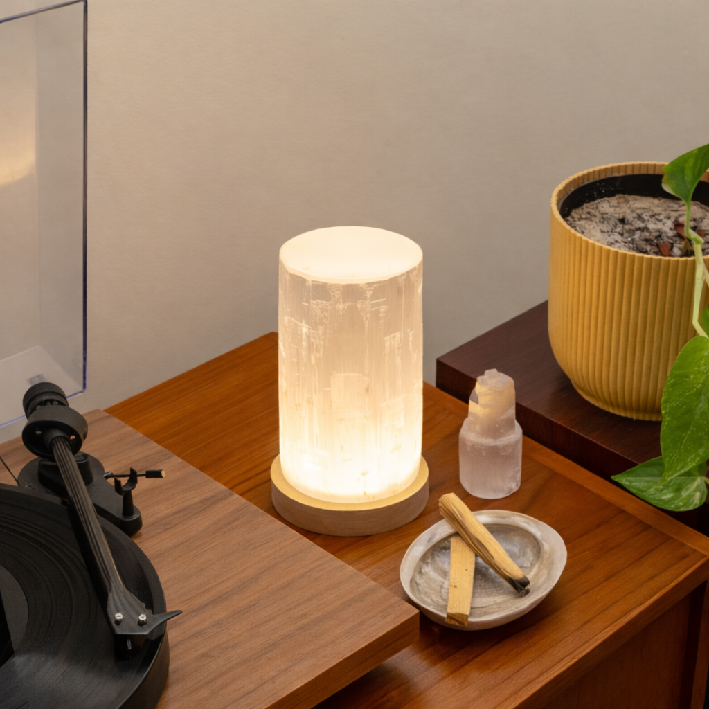 Selenite Crystal Lamp on a wooden surface with a plant and record player in the background