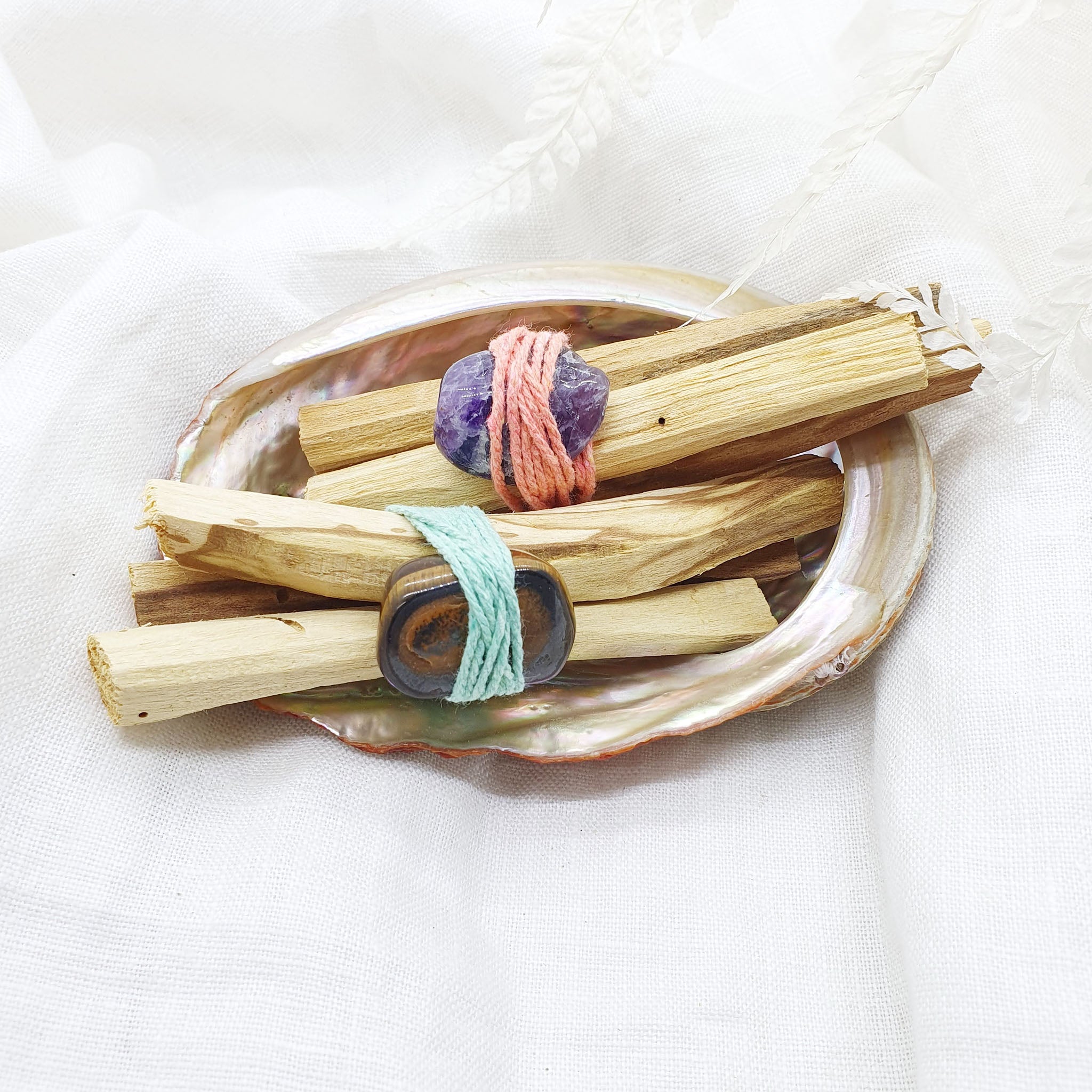 palo santo smudge sticks with tiger's eye and amethyst gemstones